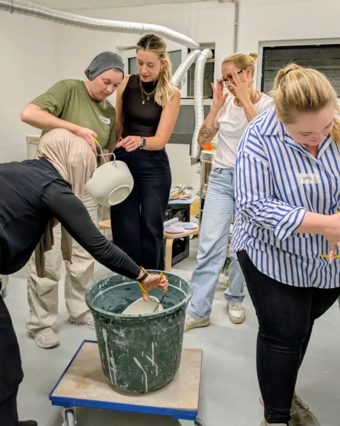 Gruppe beim gemeinsamen Keramik-Bemalen im Atelier